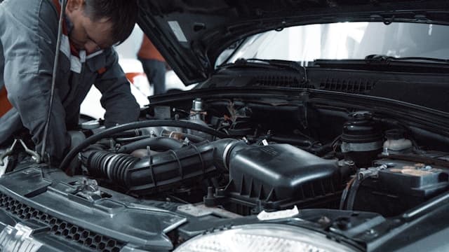 Professional mechanic performing vehicle diagnostics in workshop